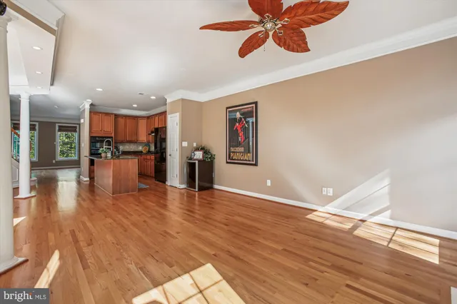 a view of an empty room with wooden floor fireplace and a window