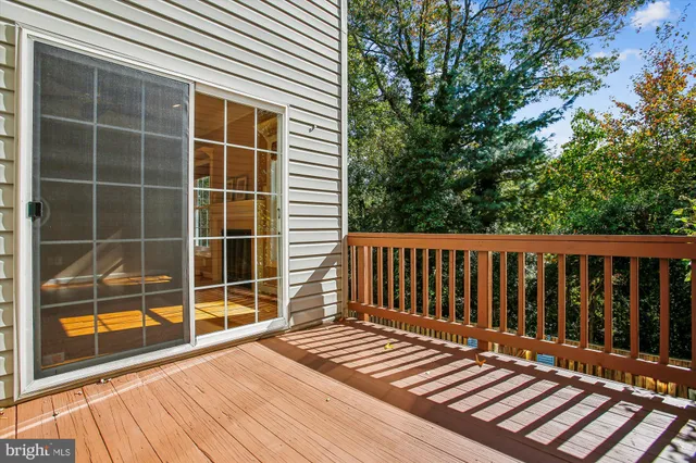 an empty room with windows fireplace and a ceiling fan