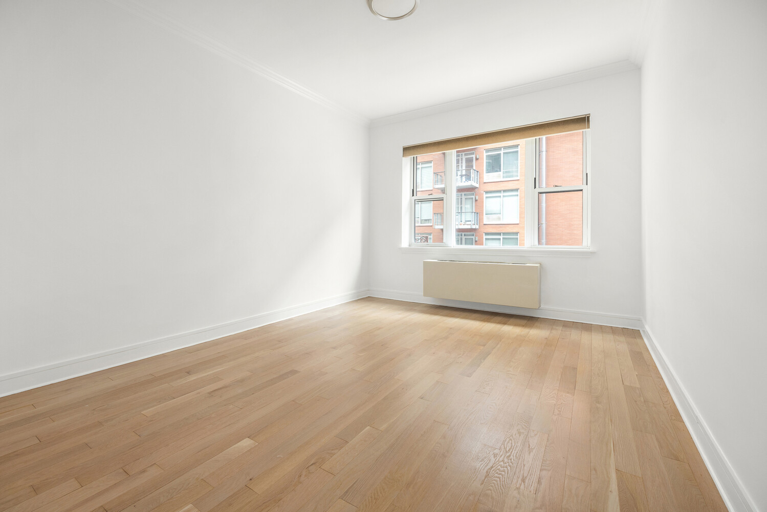 41-26 27th Street, Unit 3D Queens, NY 11101 - Photo 11 of 29 an empty room with wooden floor and windows