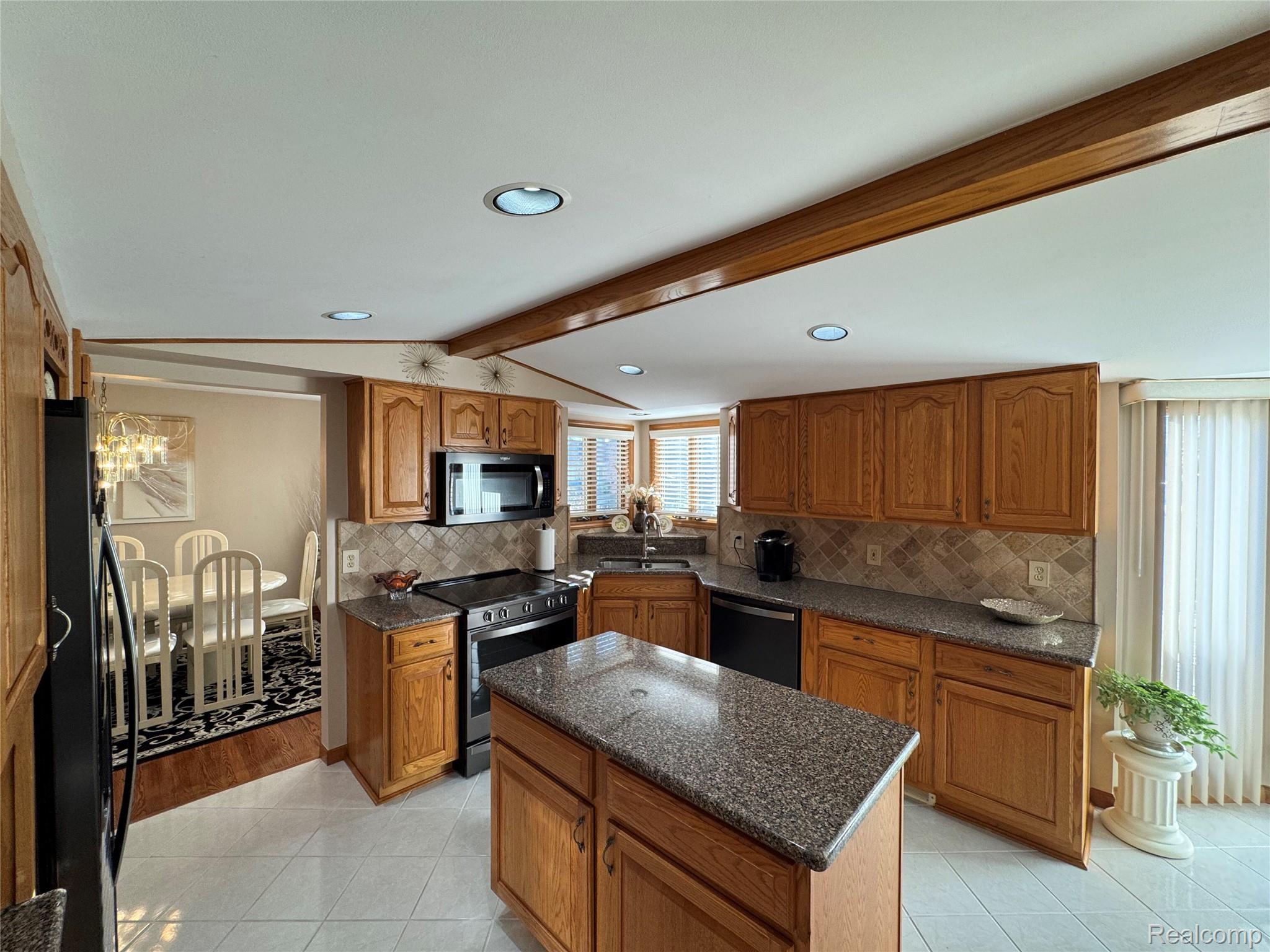 48583 Tilch Road Macomb, MI 48044 - Photo 16 of 53 Kitchen with wood finish cabinets, stainless steel appliances, dark stone countertops, tasteful backsplash, and a kitchen island