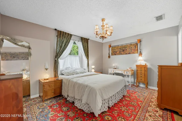a bedroom with a bed and a chandelier