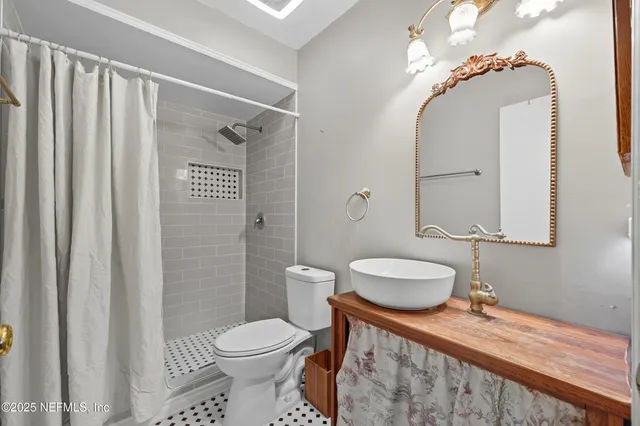 a bathroom with a granite countertop sink toilet a mirror and shower