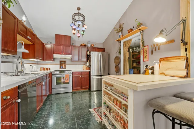 a kitchen that has a lot of cabinets a sink and a stove in it