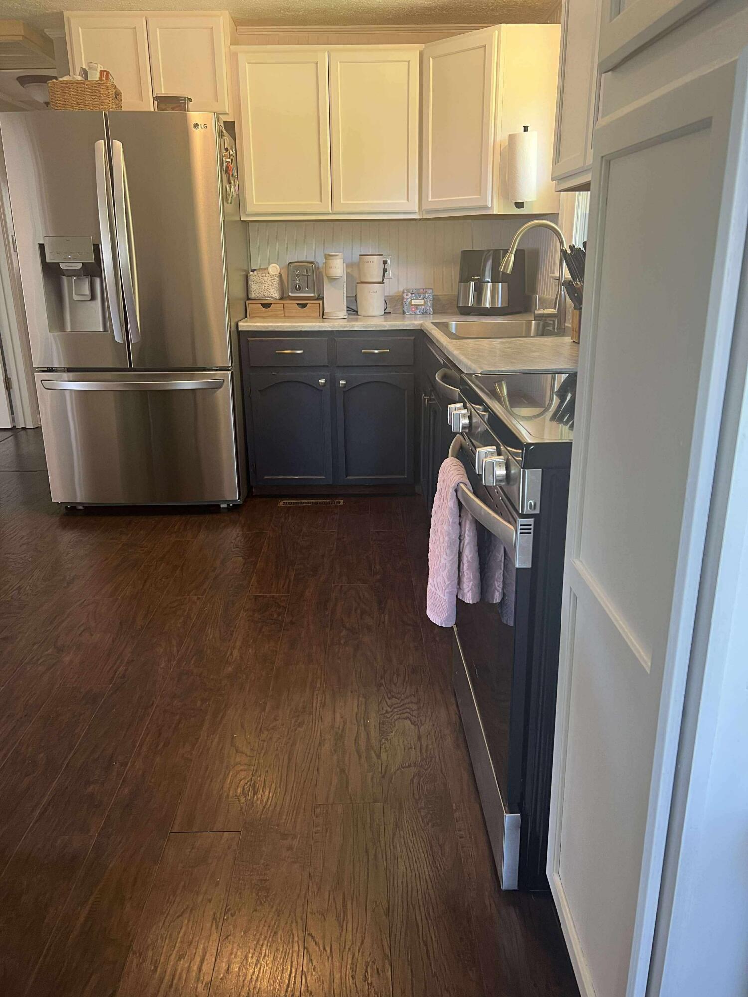 360 Rakes Road Rocky Mount, VA 24151 - Photo 5 of 32 a kitchen with stainless steel appliances granite countertop a refrigerator a sink dishwasher a stove with wooden floor and cabinets