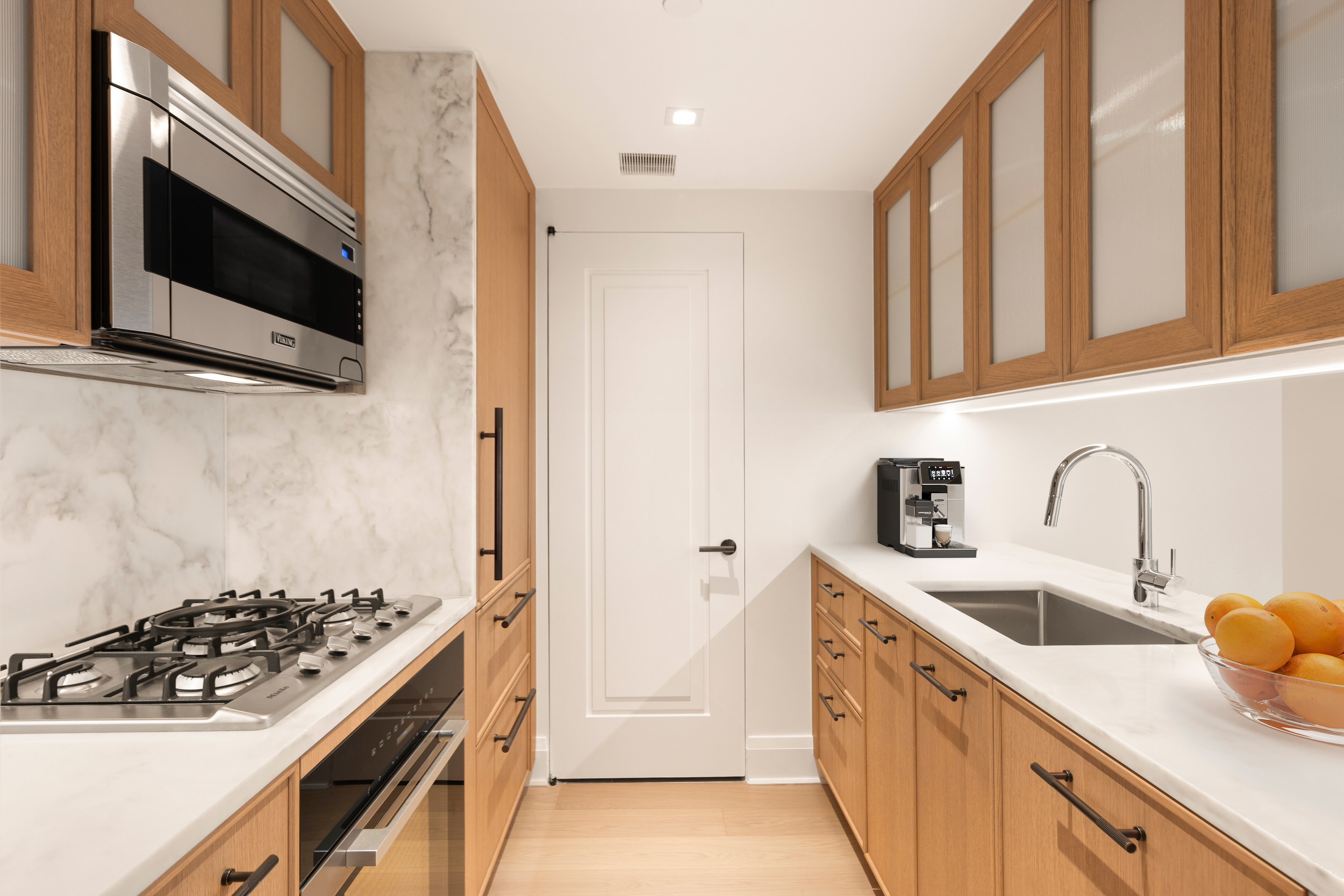 210 Warren Street, Unit 7A Manhattan, NY 10282 - Photo 3 of 9 a kitchen with stainless steel appliances a sink a stove and a microwave