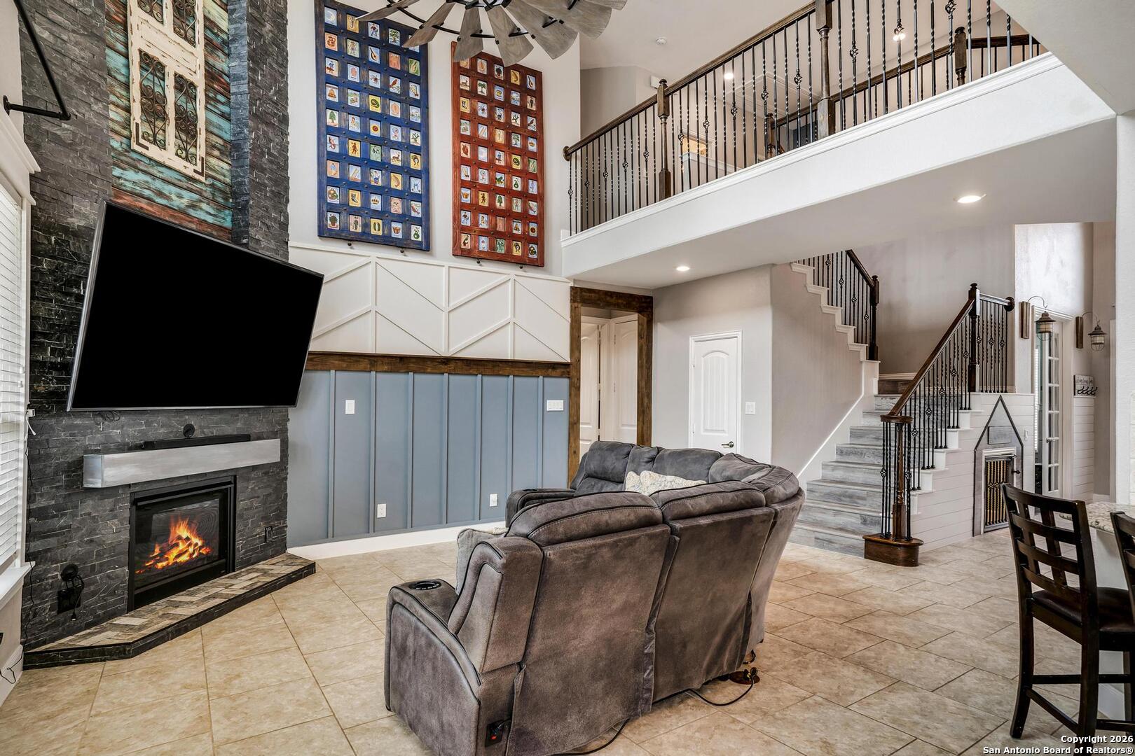 3754 Tumeric Cove Bulverde, TX 78163 - Photo 11 of 42 a living room with furniture a flat screen tv and a fireplace