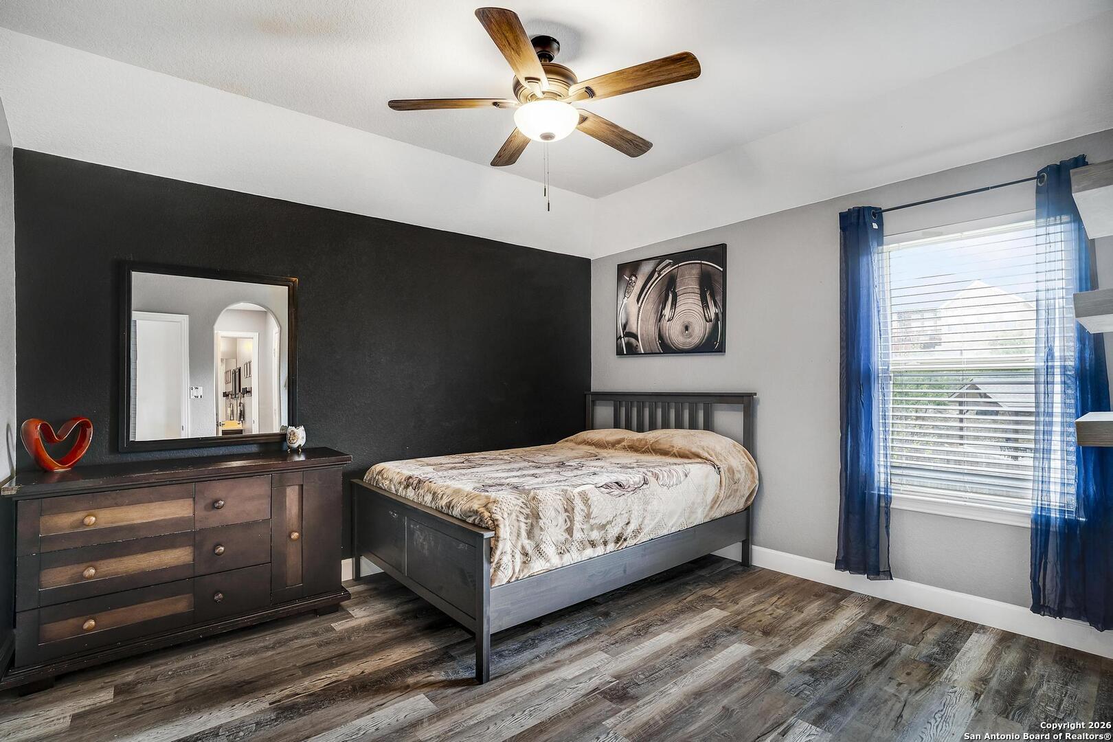 3754 Tumeric Cove Bulverde, TX 78163 - Photo 32 of 42 a bedroom with a bed and dresser with mirror