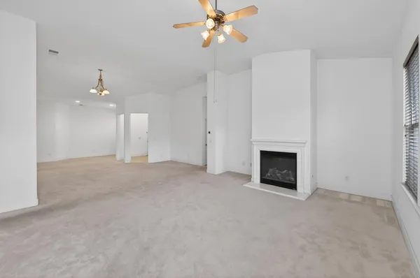 an empty room with a fireplace and fan