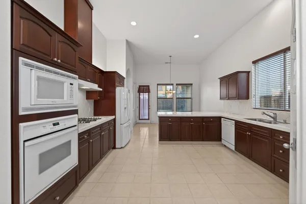 a large kitchen with stainless steel appliances granite countertop a stove refrigerator sink and cabinets