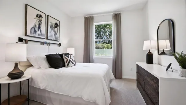 a bedroom with a bed and a mirror on the dresser