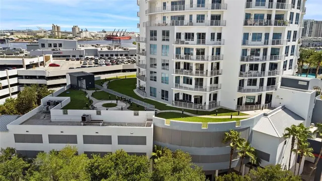 a view of a large building with a swimming pool and lawn chairs