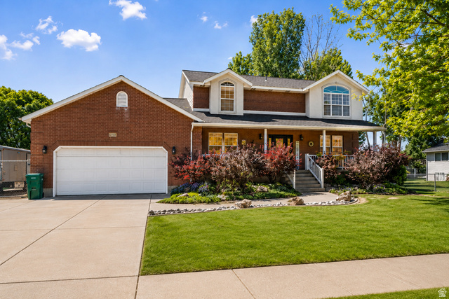 Traditional two-story residence featuring brick facade, a two-car garage & covered front porch