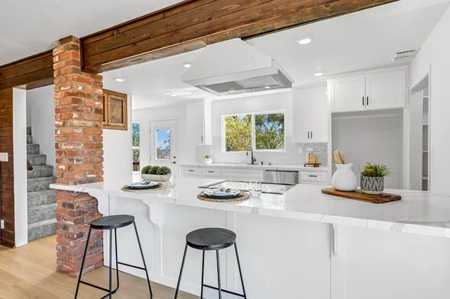 a kitchen with stainless steel appliances kitchen island granite countertop a table and chairs in it