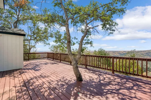 a view of balcony with wooden floor and fence