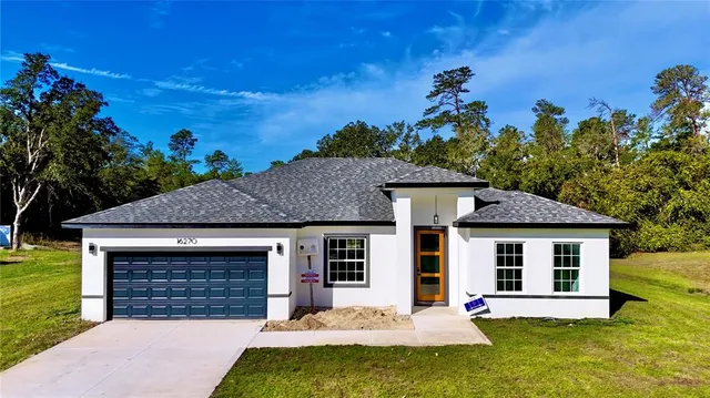 a front view of a house with a yard garage and outdoor seating