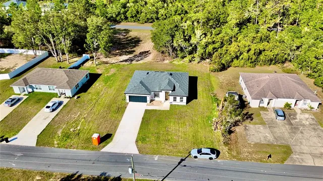 an aerial view of residential houses with yard