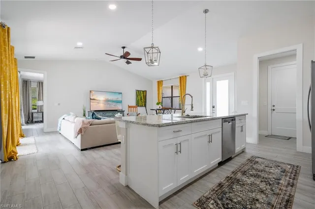 a large white kitchen with a large island oven a stove and a couch