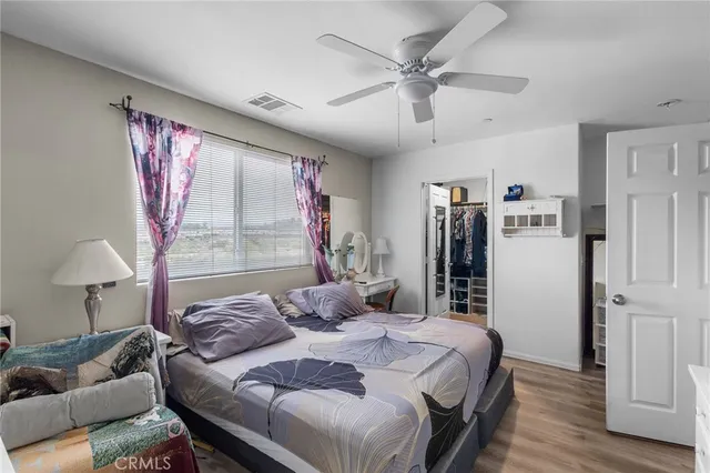 a bedroom with a bed couch and a large window