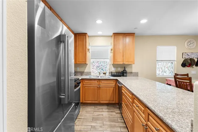 a large kitchen with stainless steel appliances granite countertop a sink and cabinets