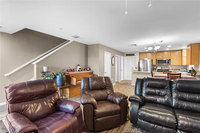 a living room with furniture and a view of kitchen