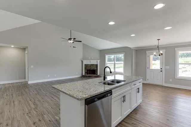 a kitchen with granite countertop kitchen island a sink appliances and a counter space