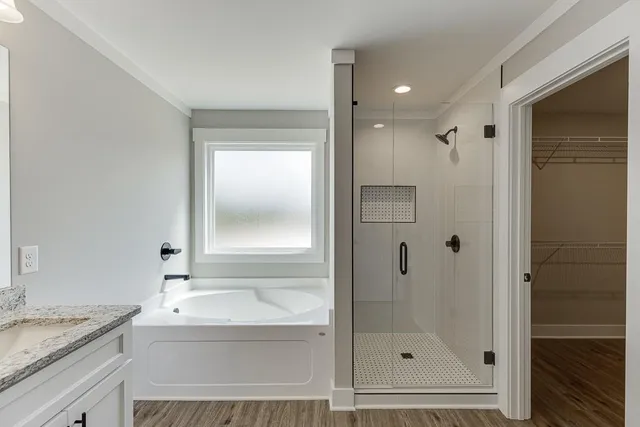 a bathroom with a granite countertop sink a mirror and a bathtub