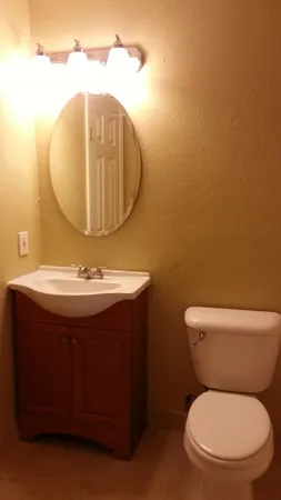 a bathroom with a toilet mirror and sink