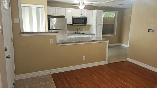 a view of kitchen with wooden floor and electronic appliances