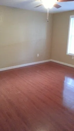 an empty room with wooden floor and windows in it