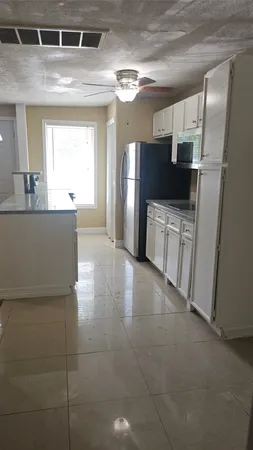 a large kitchen with cabinets and a stainless steel refrigerator