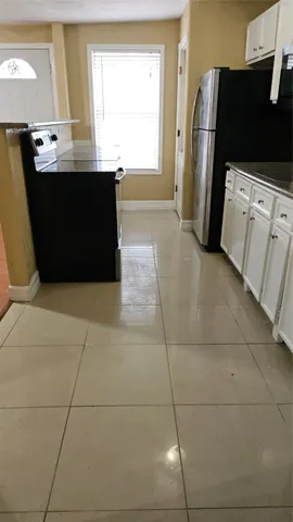 a view of kitchen with refrigerator and window