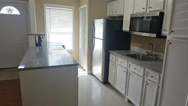 a kitchen with stainless steel appliances granite countertop a refrigerator and a sink