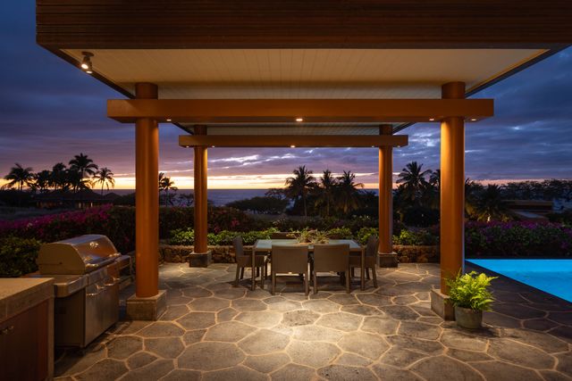 a view of a patio with a dining table and chairs next to a yard
