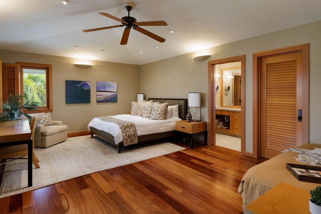 a bedroom with a bed a couch and potted plant