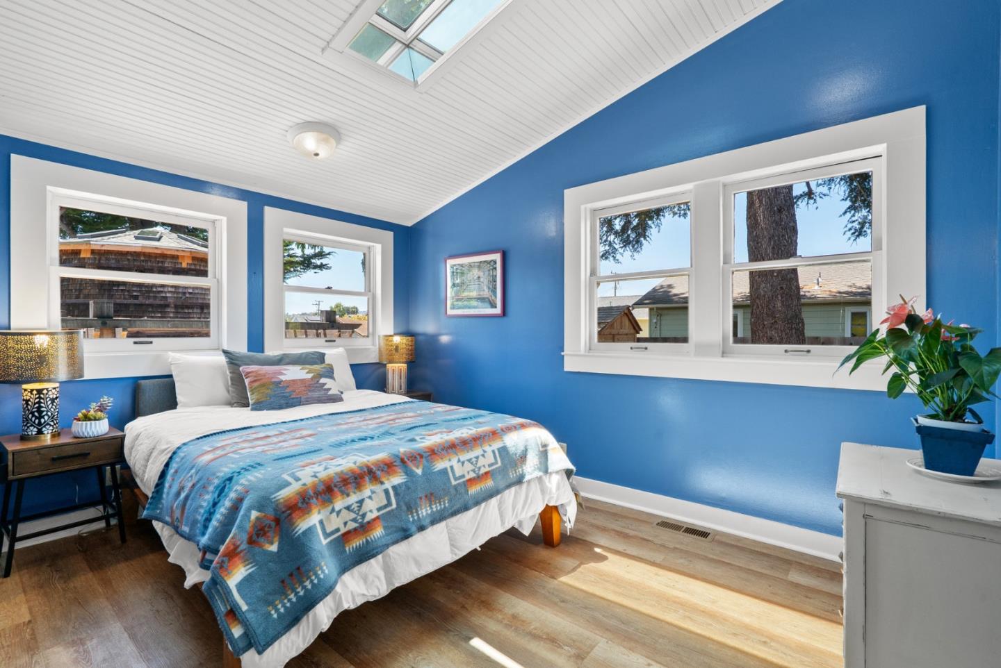505 Cayuga Street Santa Cruz, CA 95062 - Photo 17 of 57 a bedroom with a large bed a painting on the wall and a potted plant