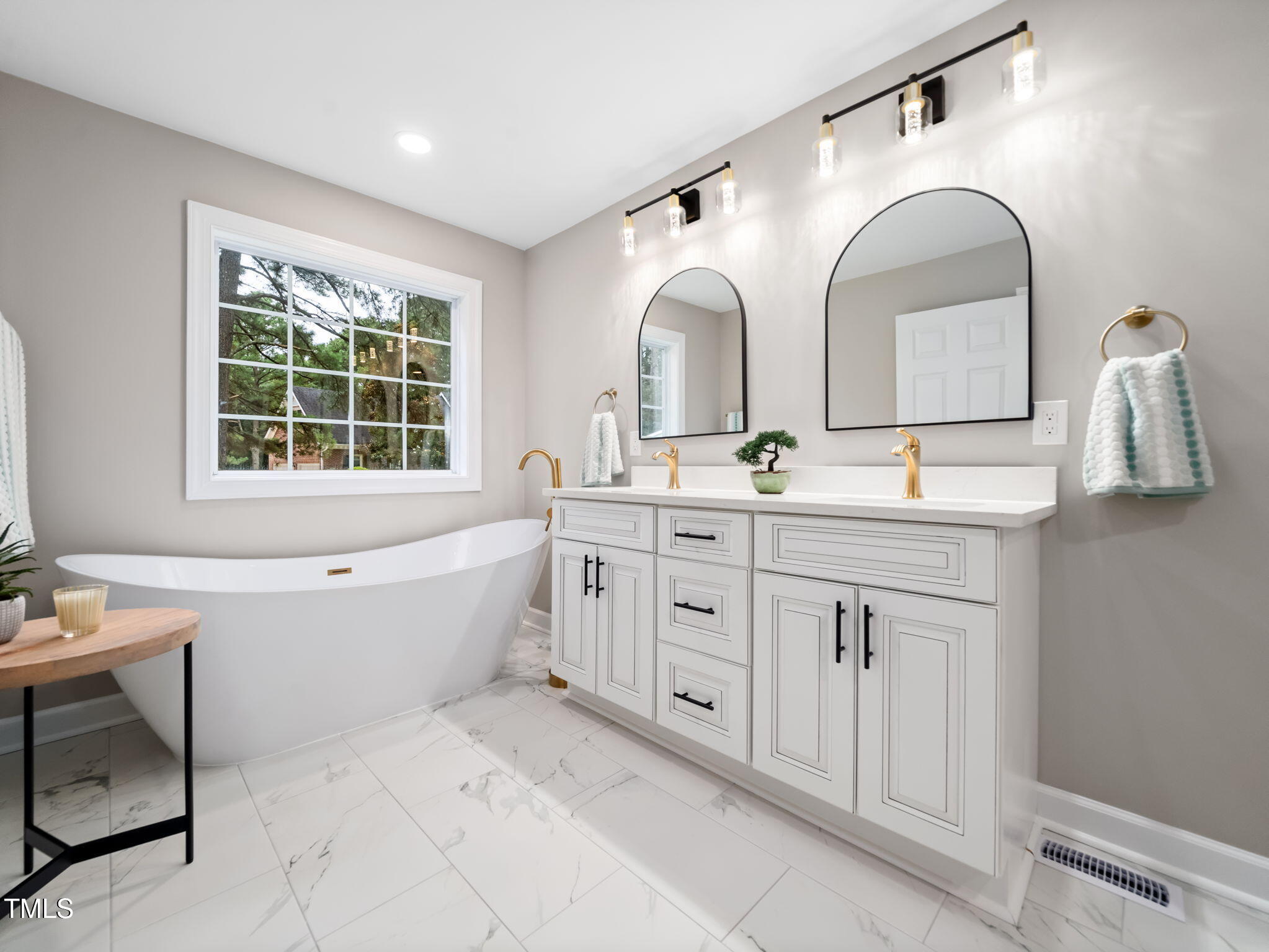 4700 Carolton Drive Raleigh, NC 27606 - Photo 14 of 29 a spacious bathroom with a double vanity sink a mirror and a bathtub