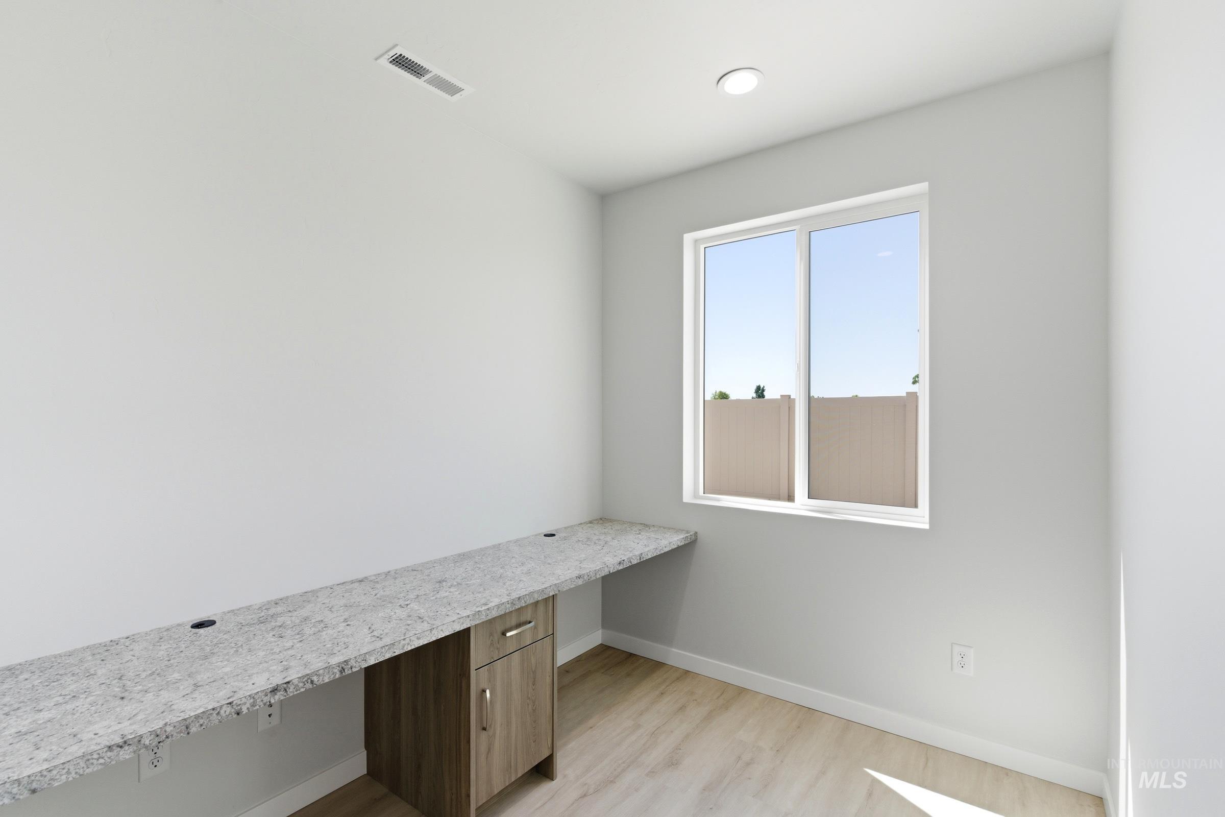13663 Redway Court Caldwell, ID 83607 - Photo 26 of 32 Dedicated interior space featuring a built-in desk with a light-toned countertop, wood-finish flooring, a contemporary window, and recessed lighting