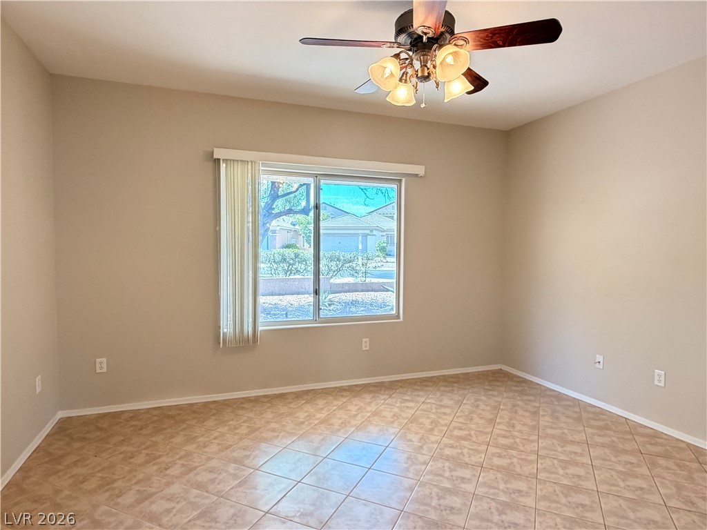 2523 Romanza Road Henderson, NV 89052 - Photo 15 of 24 Well-lit room features practical tiled flooring and a convenient ceiling fan for comfortable living.