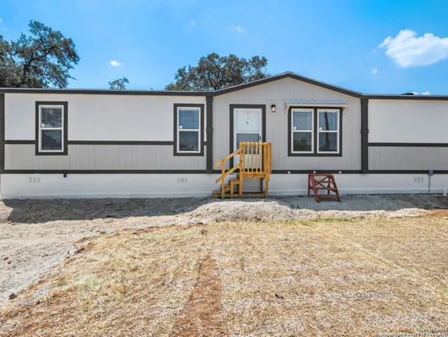 a view of a house with backyard and sitting area
