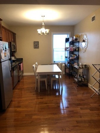 61 Wait Street, Unit 3 Boston, MA 02120 - Photo 11 of 11 a dining room with furniture a chandelier and wooden floor