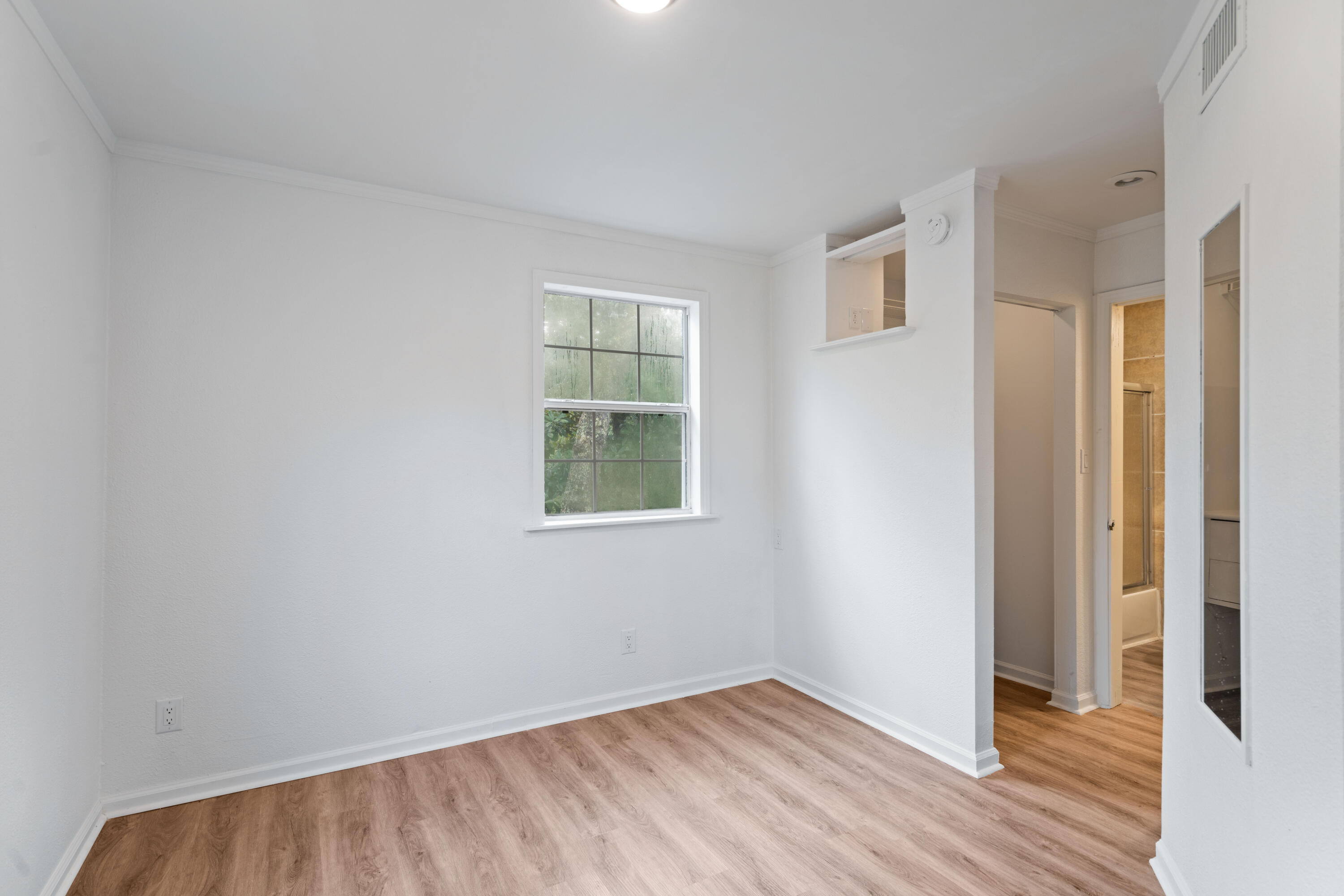 200 East Harborview Road Santa Rosa Beach, FL 32459 - Photo 12 of 20 an empty room with wooden floor and windows