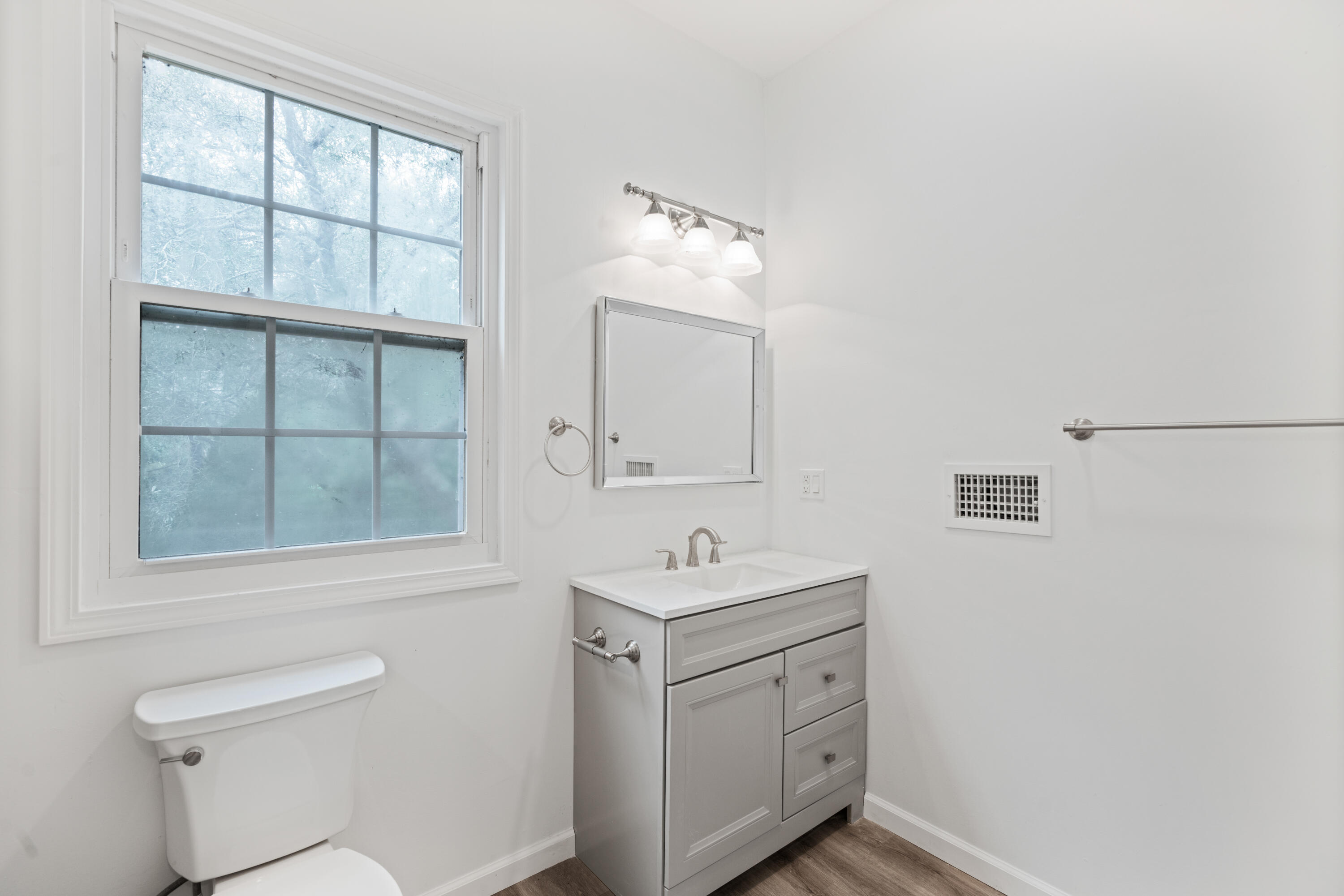 200 East Harborview Road Santa Rosa Beach, FL 32459 - Photo 17 of 20 a bathroom with a toilet sink vanity and mirror