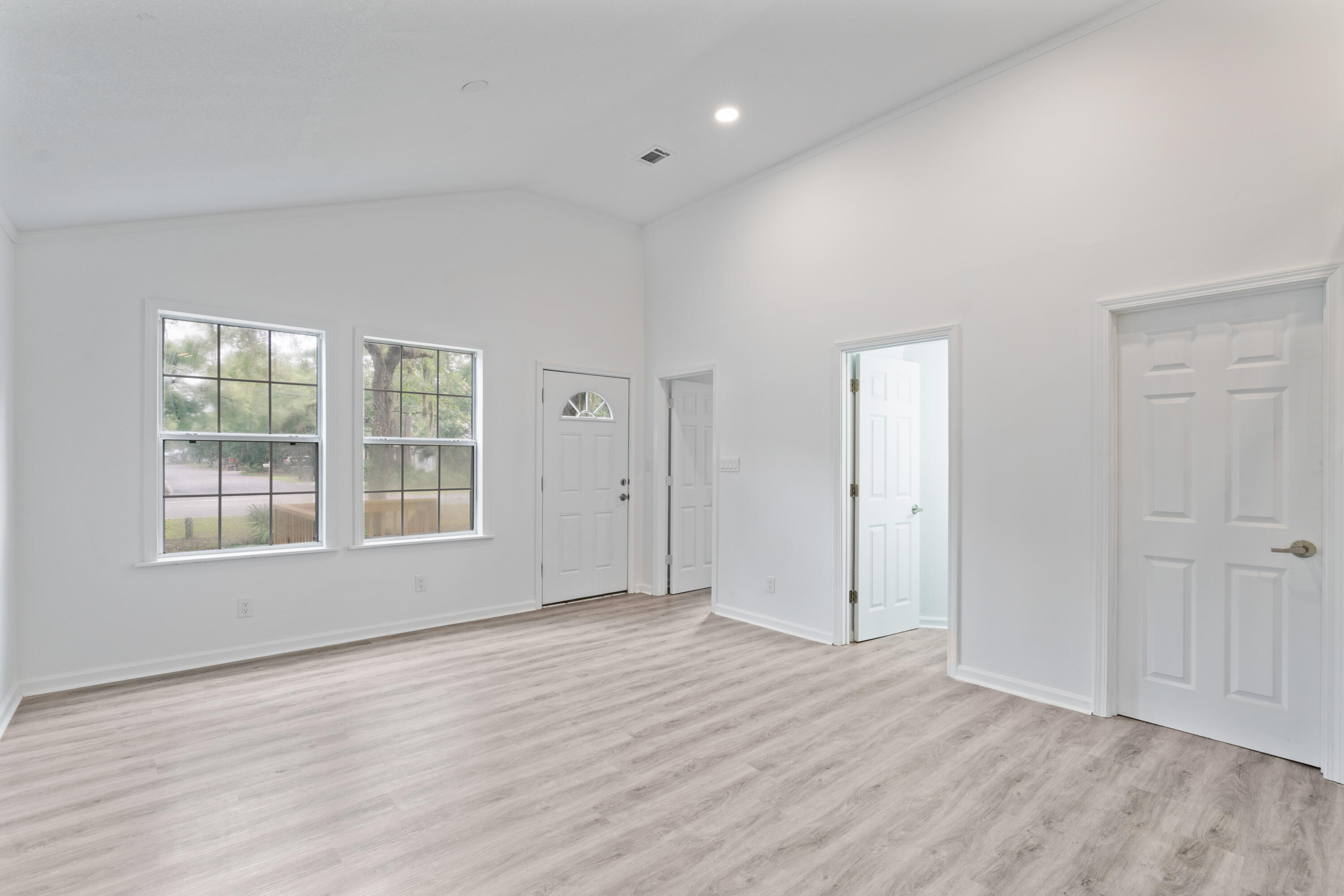 200 East Harborview Road Santa Rosa Beach, FL 32459 - Photo 7 of 20 an empty room with wooden floor and windows