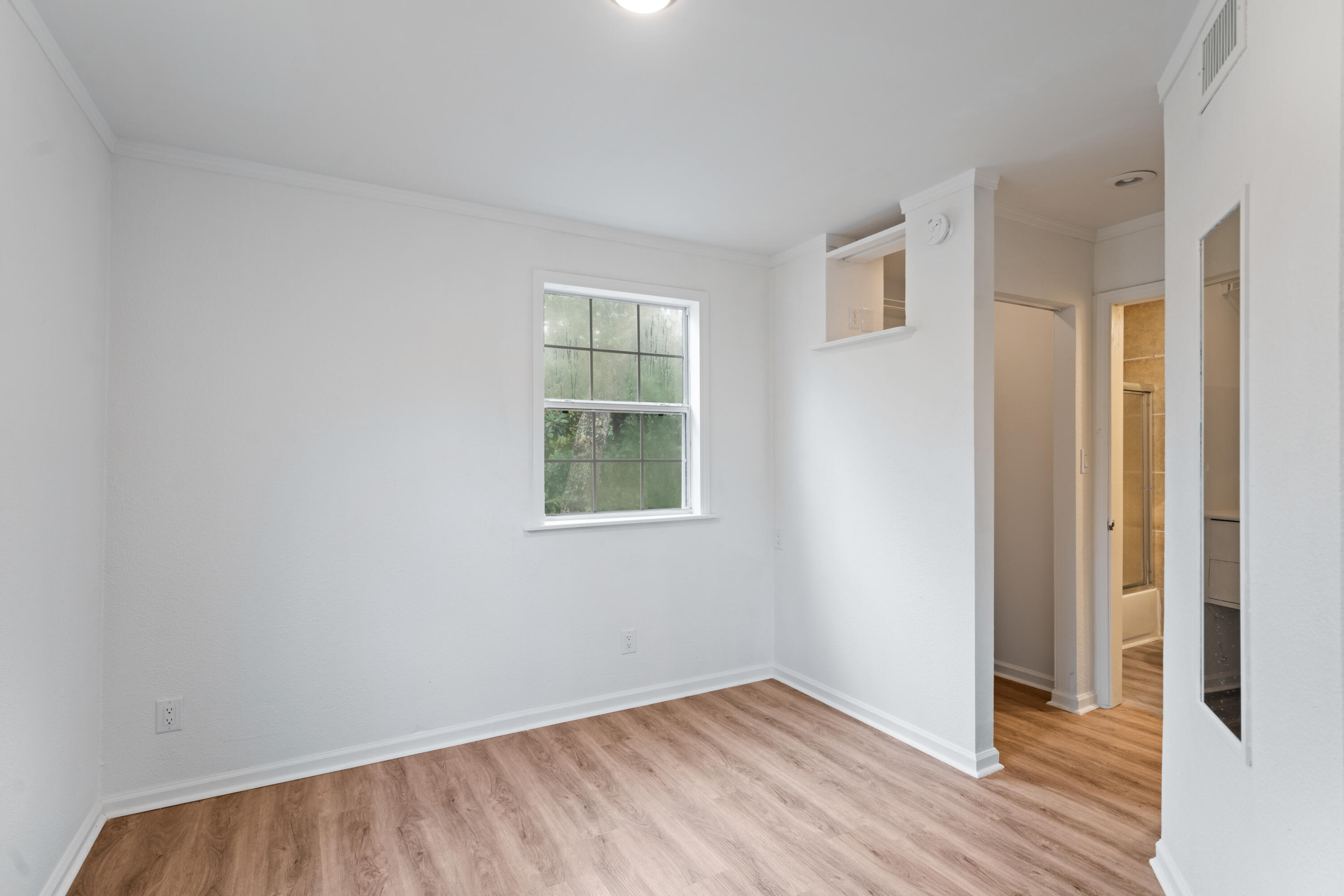 200 East Harborview Road Santa Rosa Beach, FL 32459 - Photo 10 of 20 an empty room with wooden floor and windows