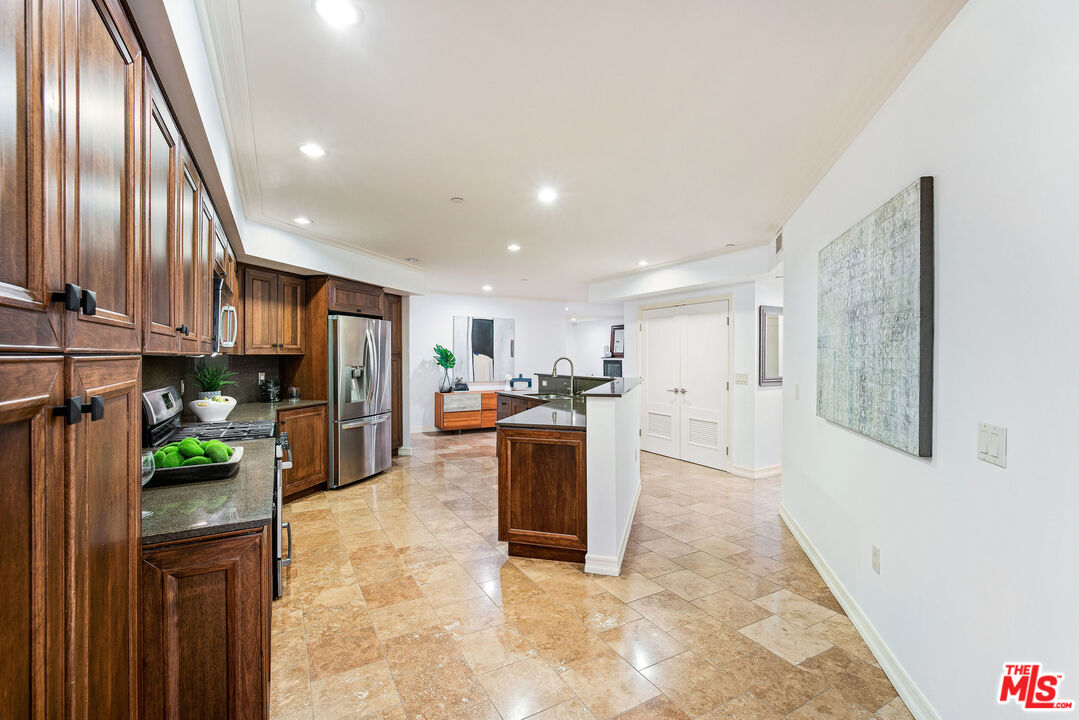 1420 South Bundy Drive, Unit 101 Los Angeles, CA 90025 - Photo 7 of 37 a kitchen with stainless steel appliances kitchen island granite countertop a refrigerator a stove top oven a sink and dishwasher
