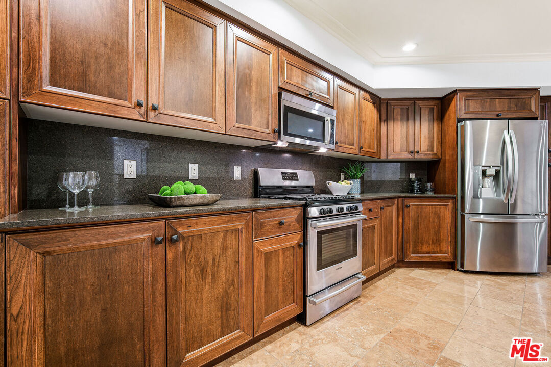 1420 South Bundy Drive, Unit 101 Los Angeles, CA 90025 - Photo 9 of 37 a kitchen with stainless steel appliances granite countertop a refrigerator sink and cabinets