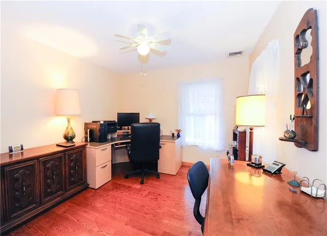 a view of a workspace with furniture and a window