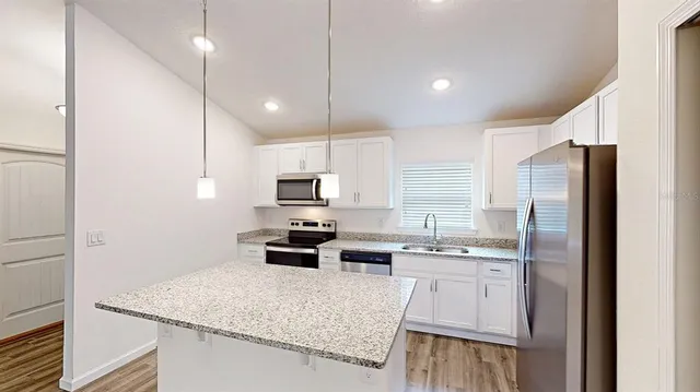 a kitchen with stainless steel appliances granite countertop a refrigerator stove and oven