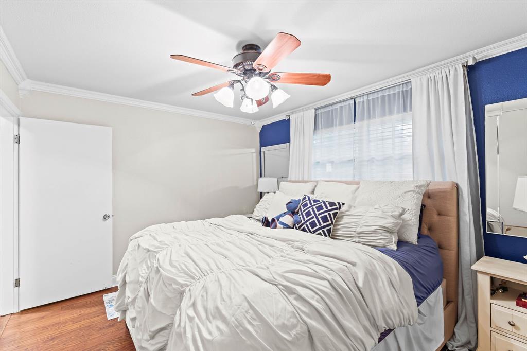 934 North Maple Street Muenster, TX 76252 - Photo 13 of 39 a bedroom with a bed and a chandelier
