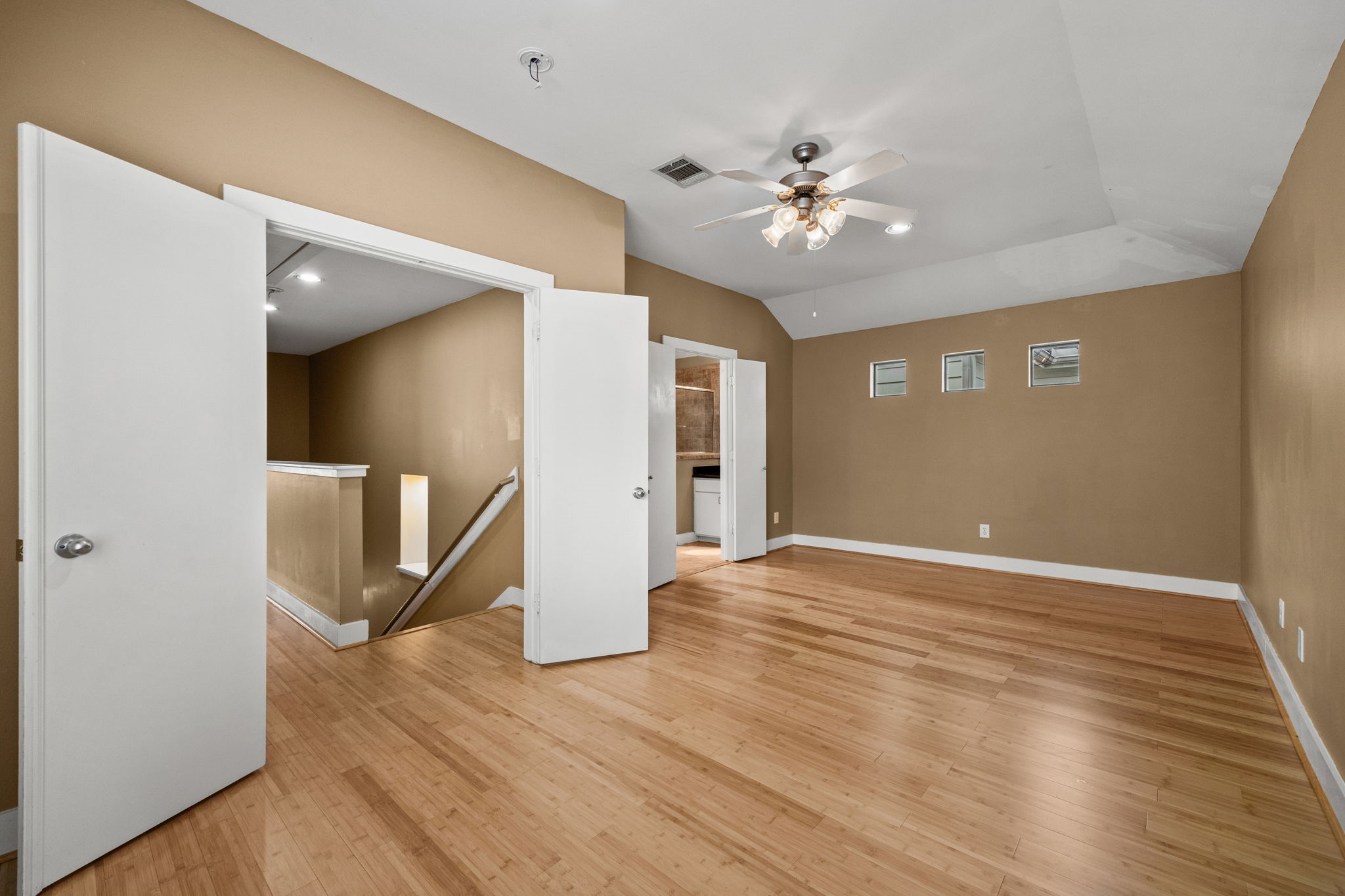 5951 S Loop East, Unit 7 Houston, TX 77033 - Photo 11 of 22 a view of an empty room with wooden floor and a ceiling fan